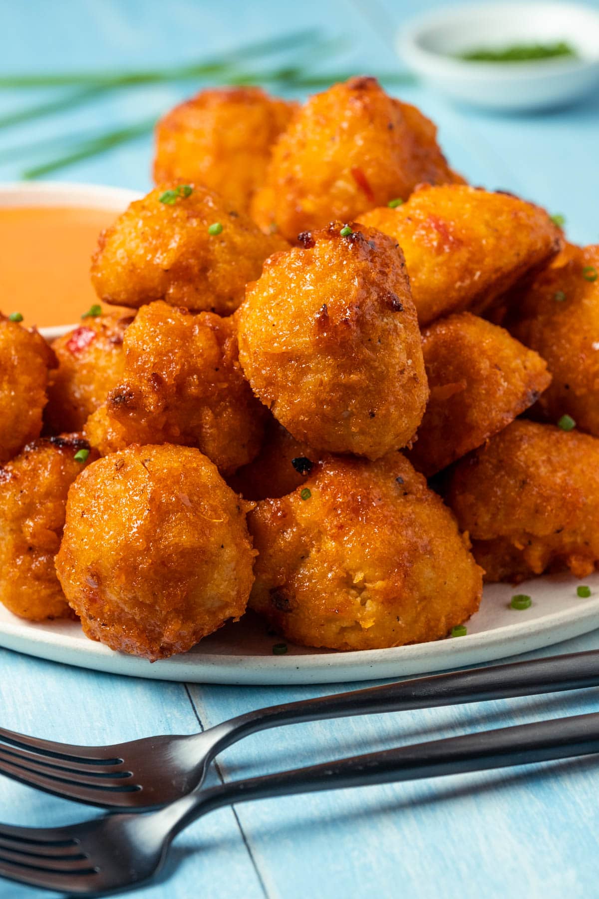 Bang bang cauliflower with chopped chives on a plate.