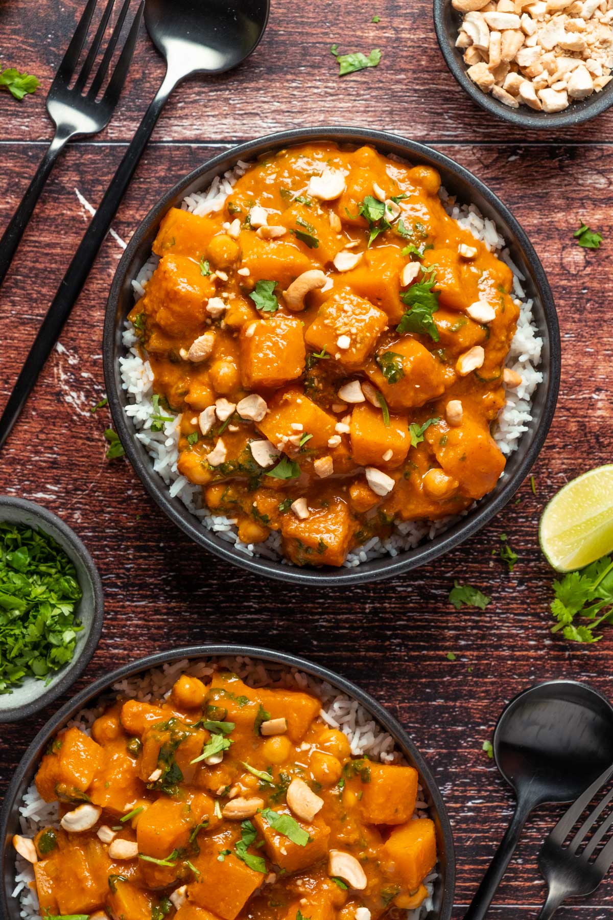 Vegan butternut squash curry with rice in black bowls.