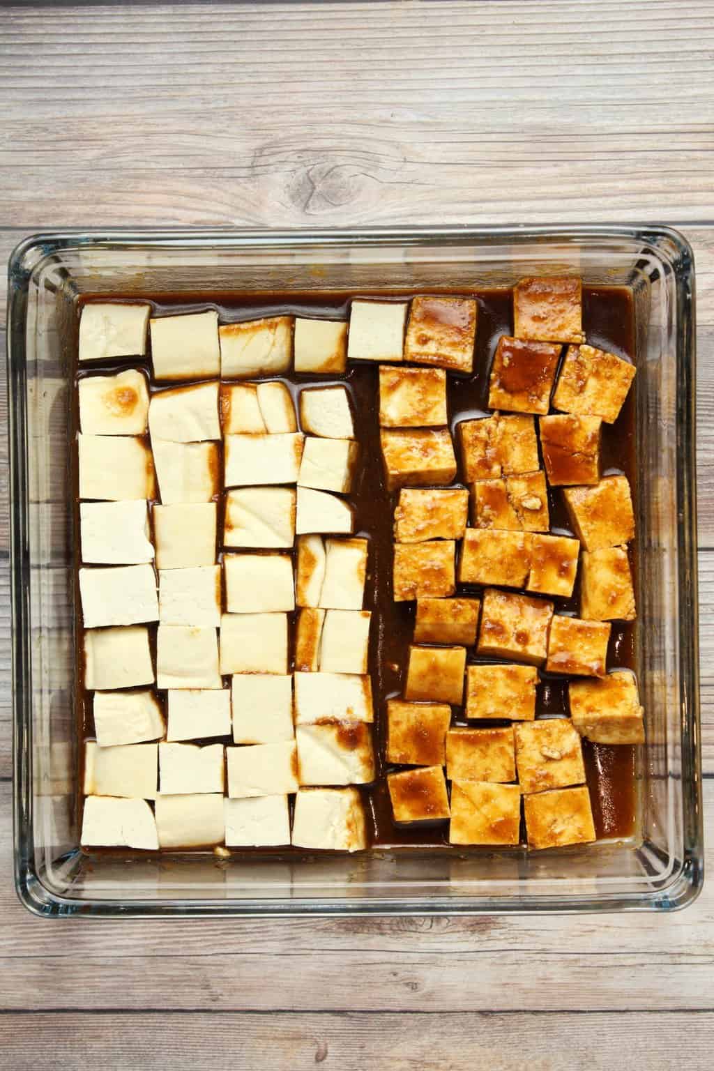 Tofu marinading in a tofu marinade sauce in a glass dish. 