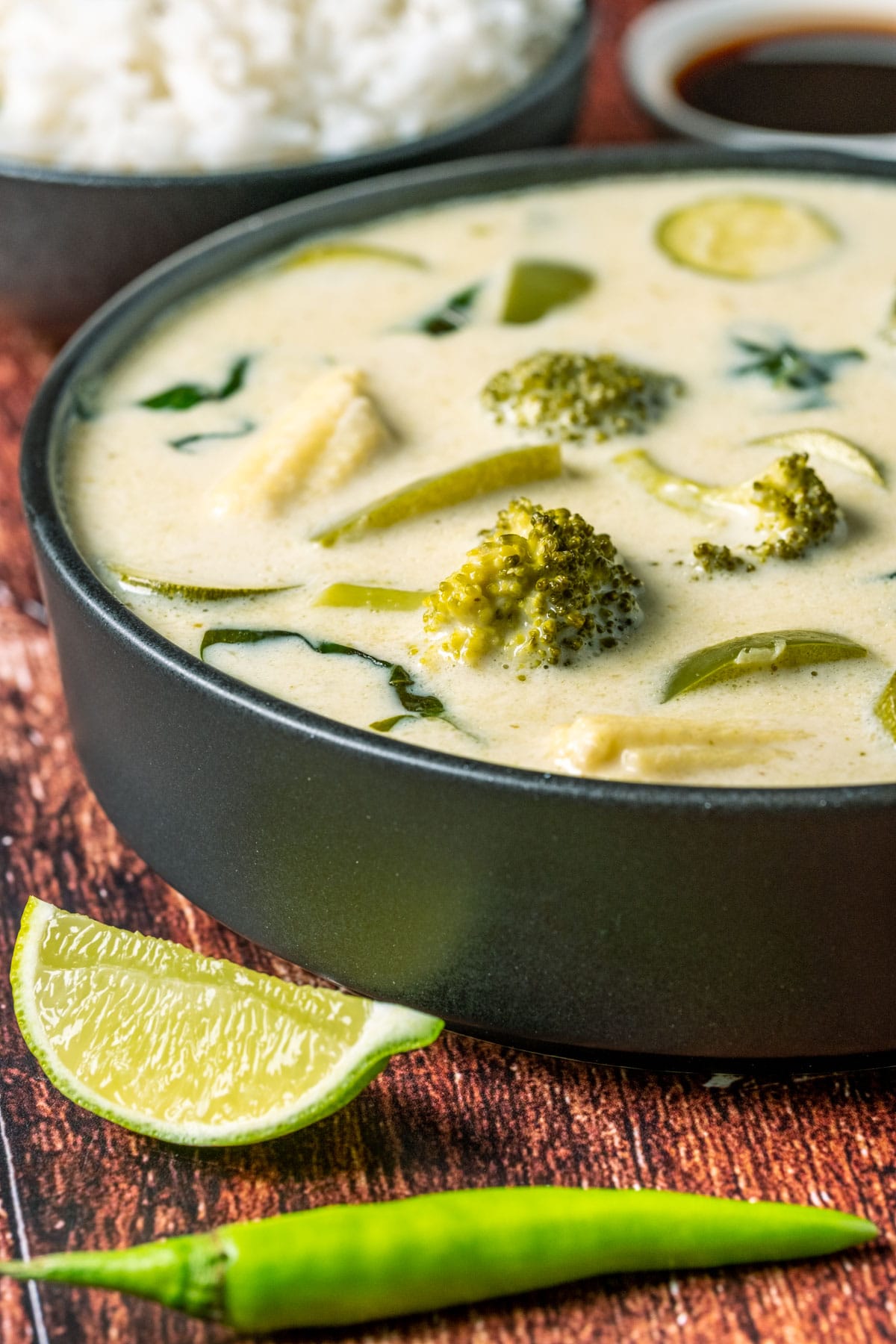 Vegan Thai green curry in a black bowl.