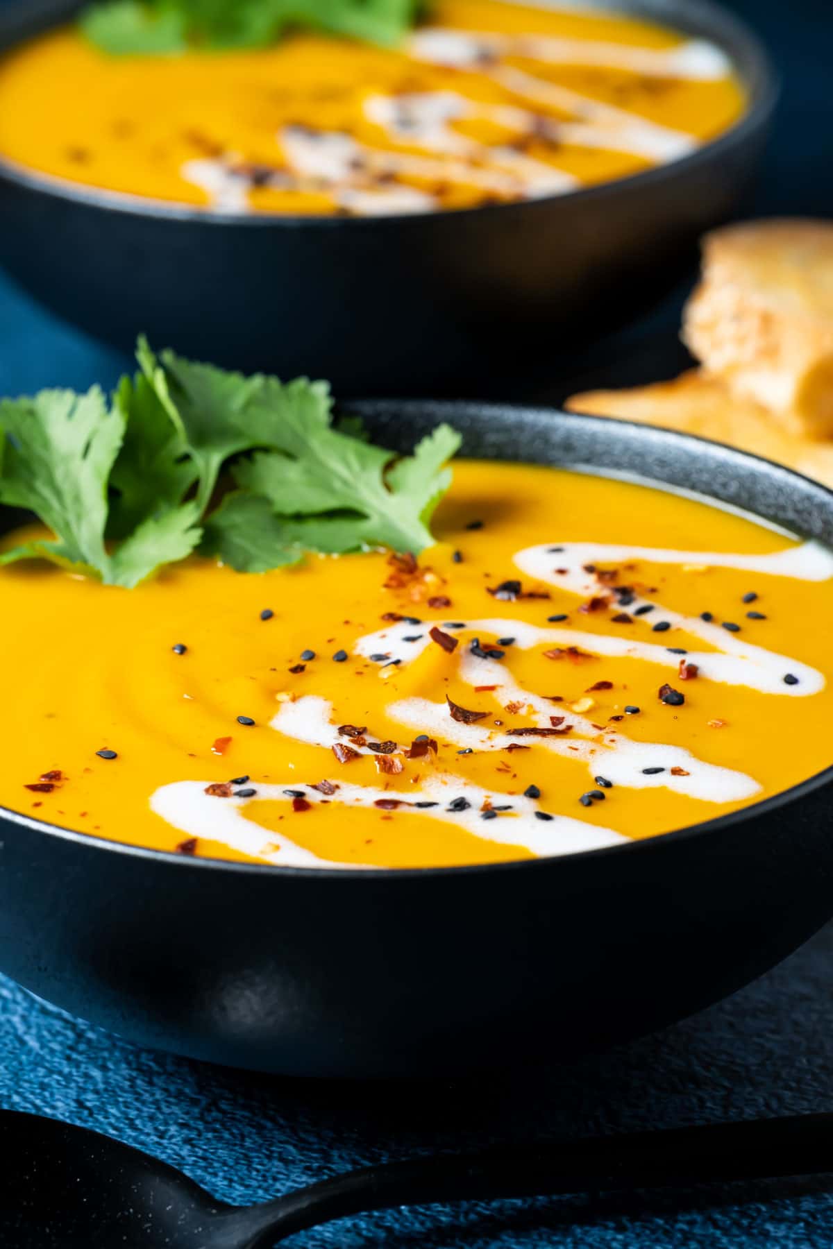 Thai sweet potato soup topped with fresh cilantro in a black bowl.