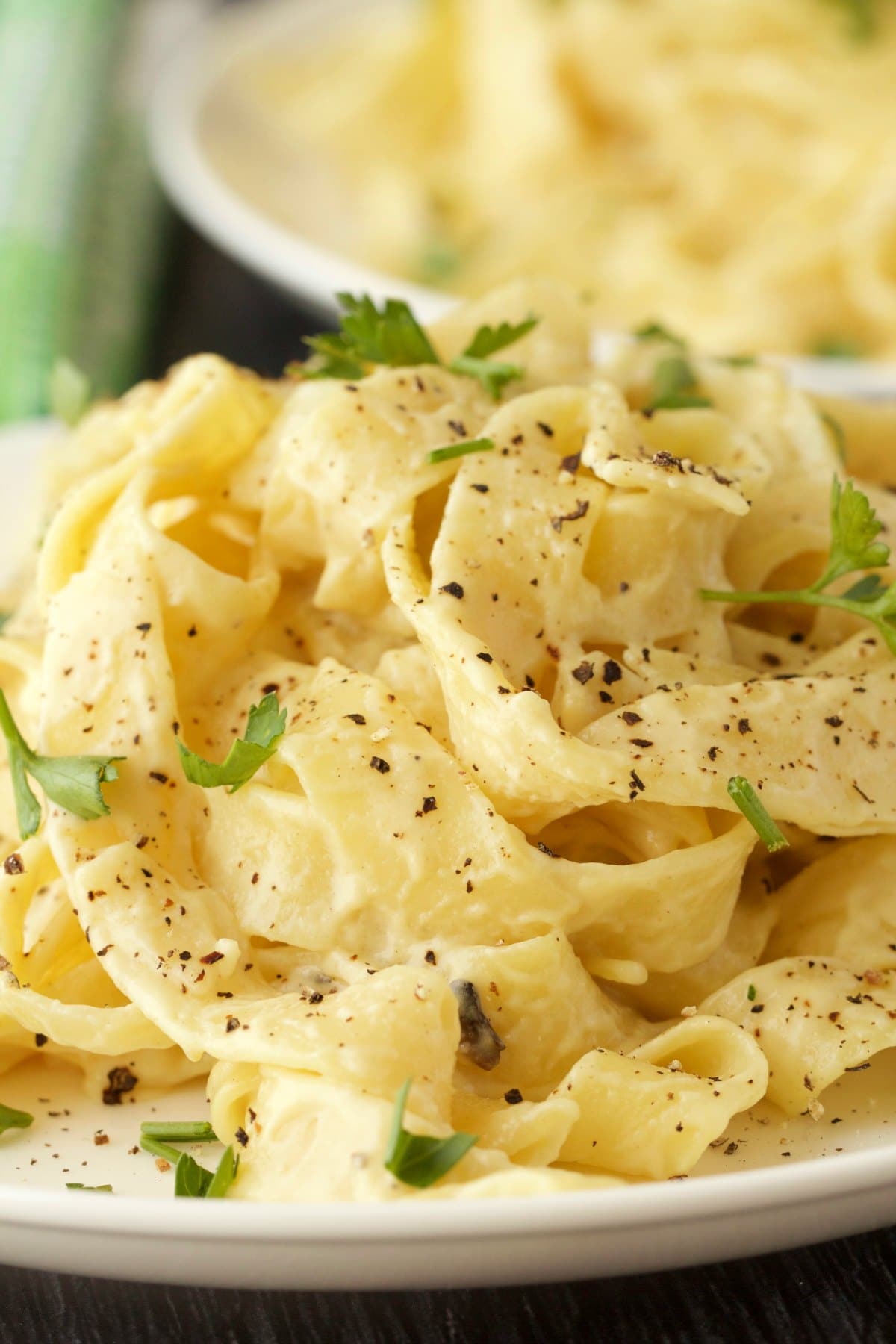 Vegan fettucine with alfredo sauce, black pepper and fresh parsley. 