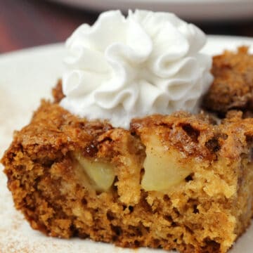 Slice of vegan apple cake on a white plate.