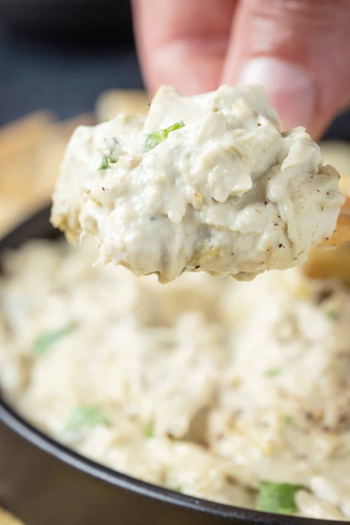 Artichoke dip on a cracker.