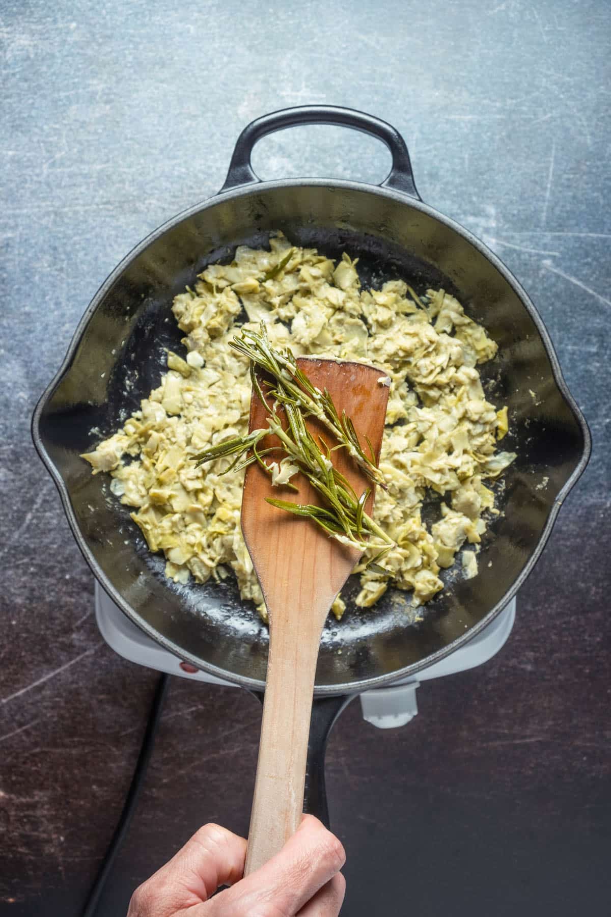 Removing rosemary from pan.