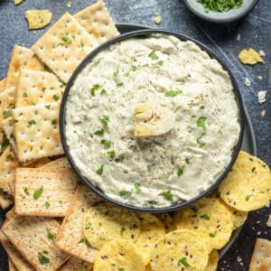 Vegan artichoke dip in a black bowl.