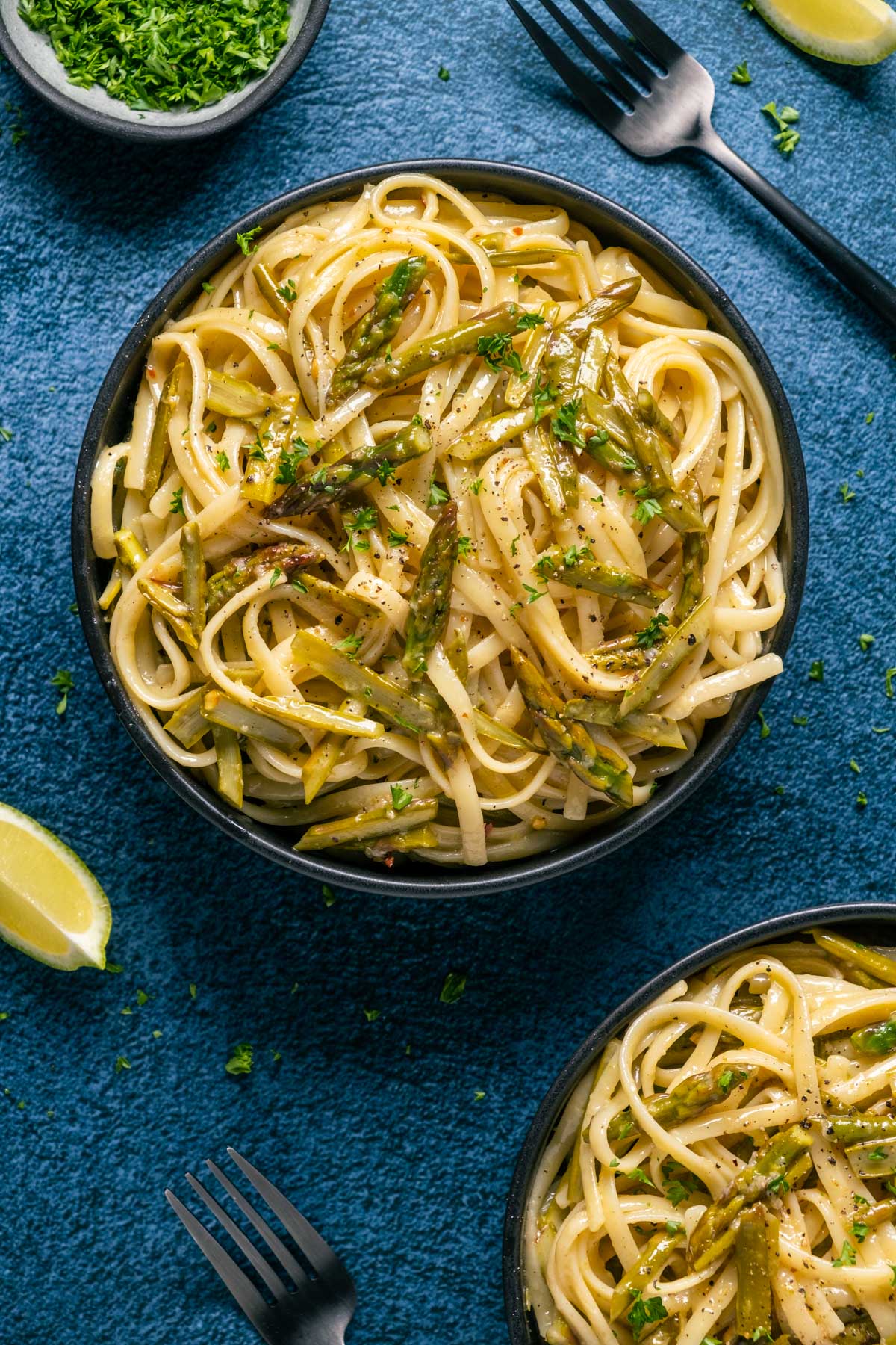 Asparagus pasta in black bowls.