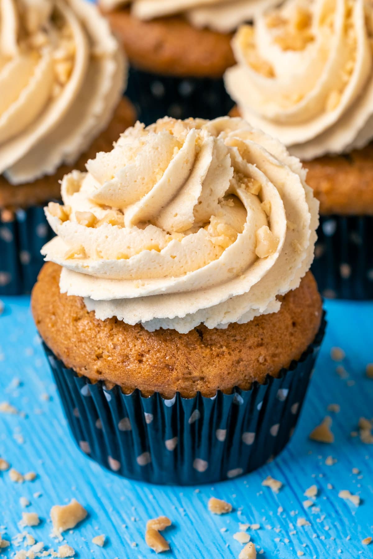 Vegan banana cupcakes topped with peanut butter frosting and crushed peanuts.