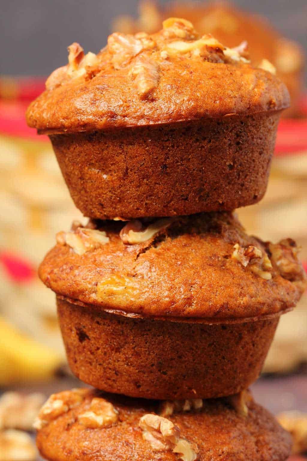 Vegan banana muffins stacked up on top of each other. 