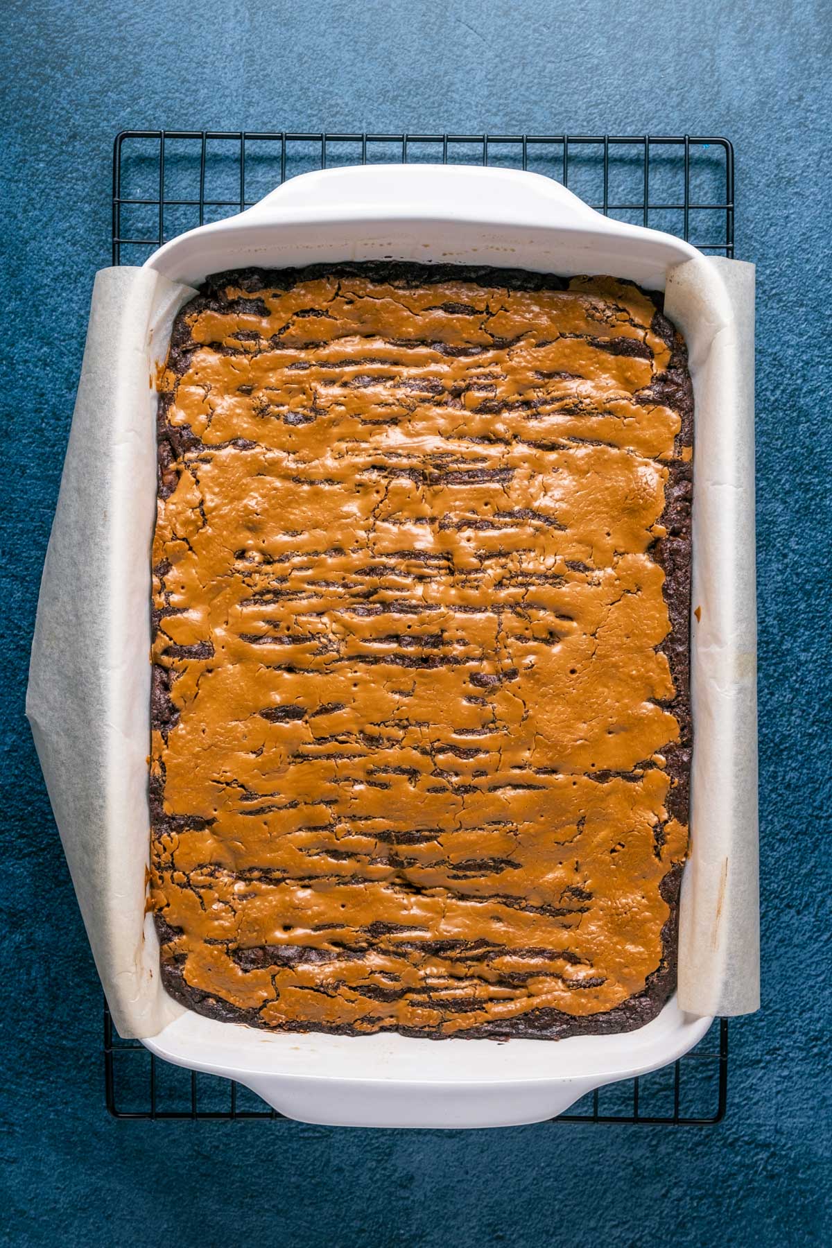 Vegan biscoff brownies freshly baked in a white baking dish.