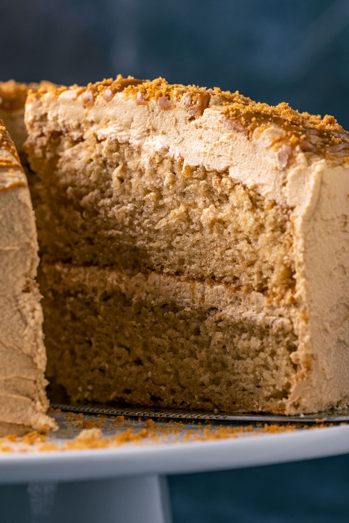 Sliced vegan biscoff cake on a white cake stand.