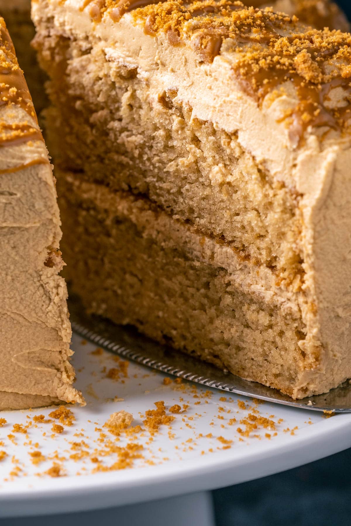 Sliced vegan biscoff cake on a white cake stand.