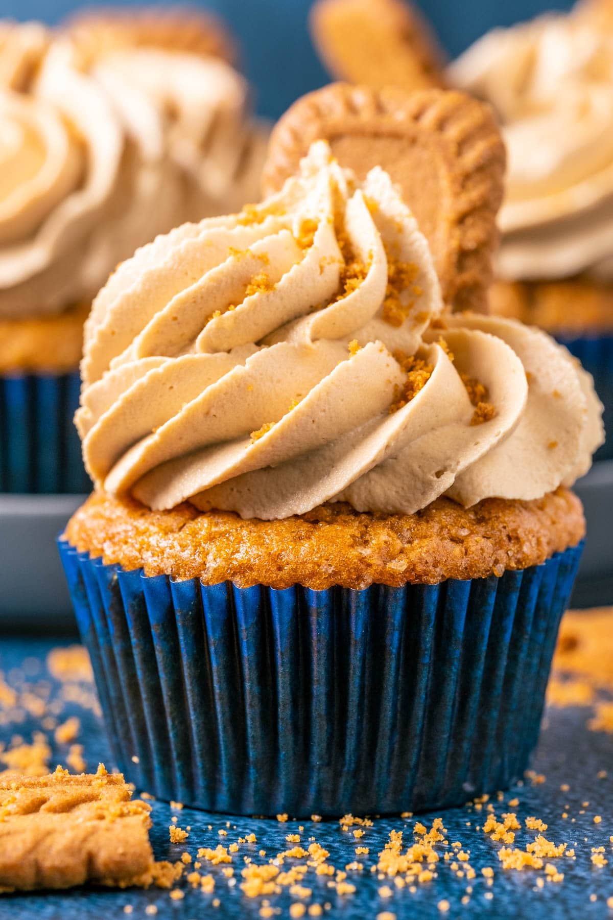 Vegan biscoff cupcake topped with frosting and biscoff cookies.