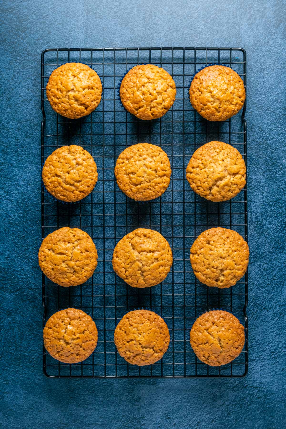 Vegan biscoff cupcakes cooling on a wire cooling rack.