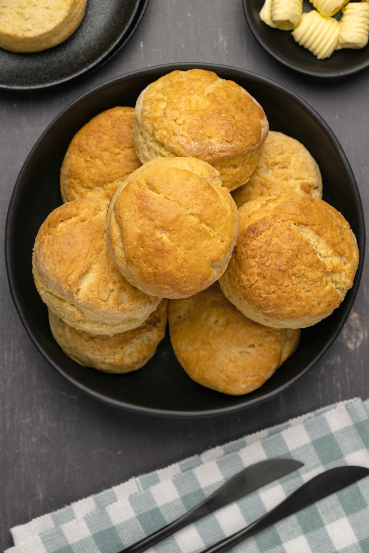 Vegan biscuits stacked up on a black plate. 