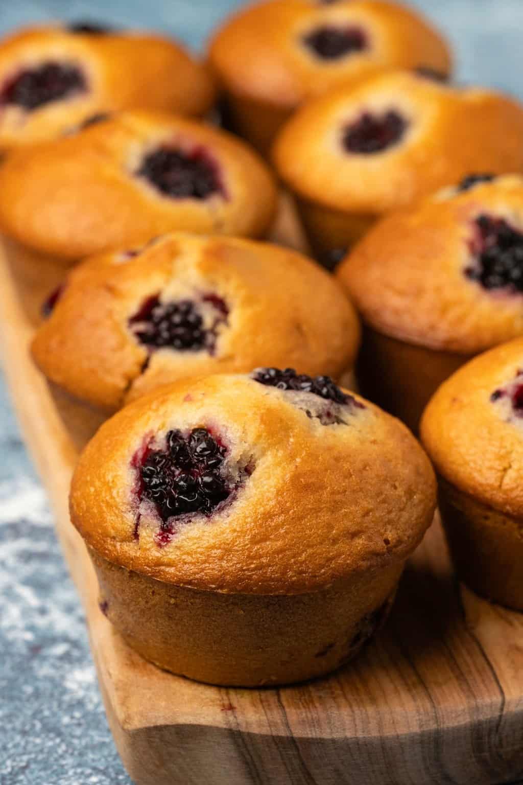 Vegan blackberry muffins on a wooden board. 