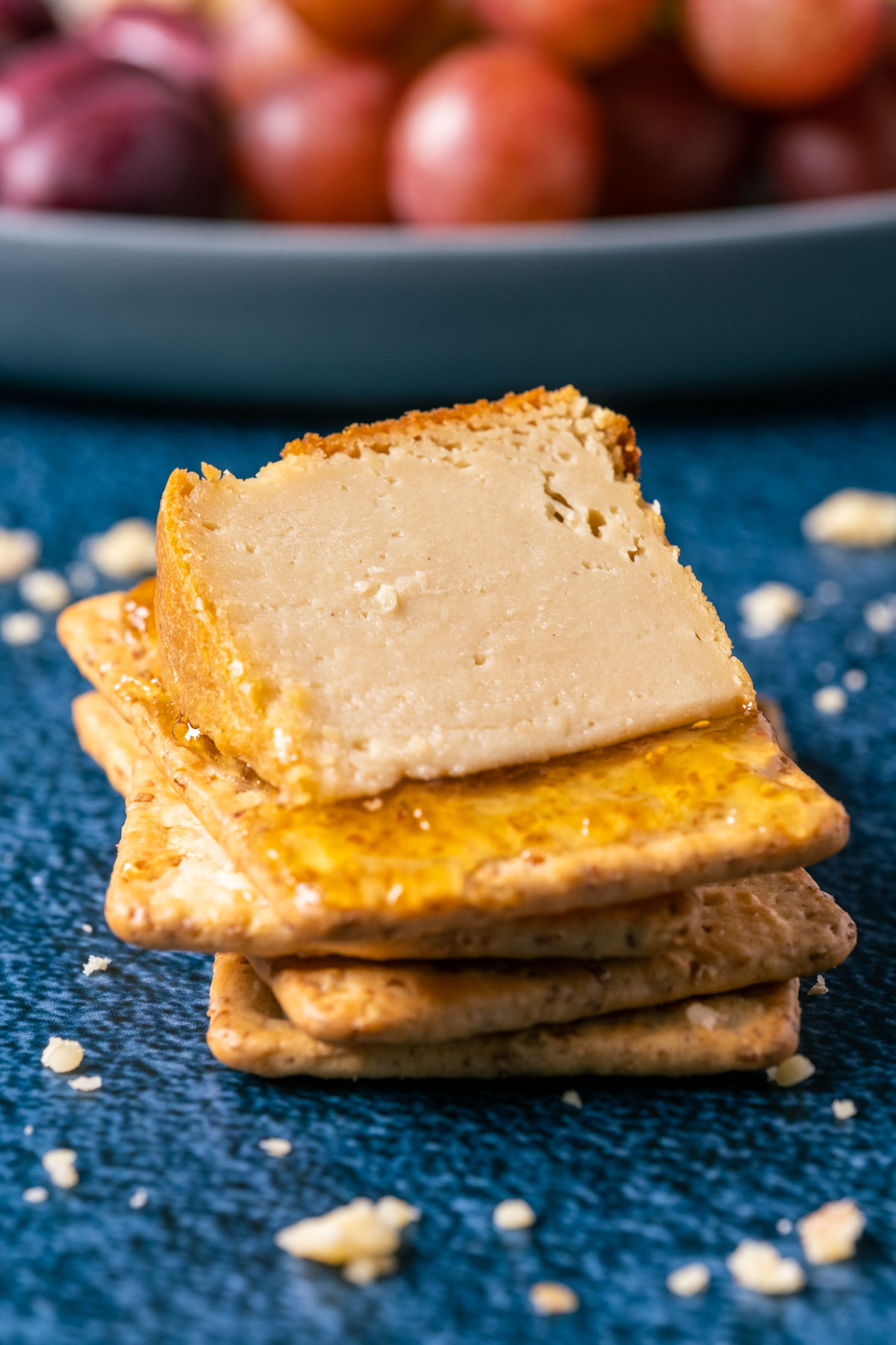 Slice of brie cheese on a stack of crackers.