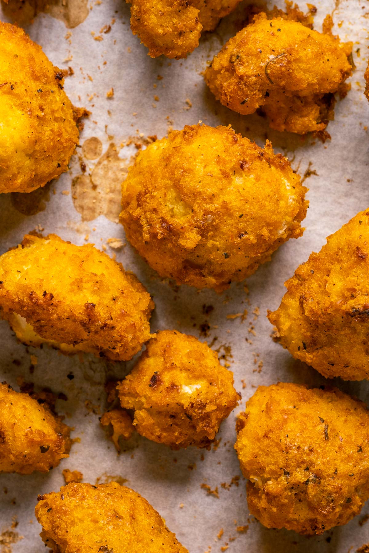 Buffalo cauliflower wings on a parchment lined baking tray.