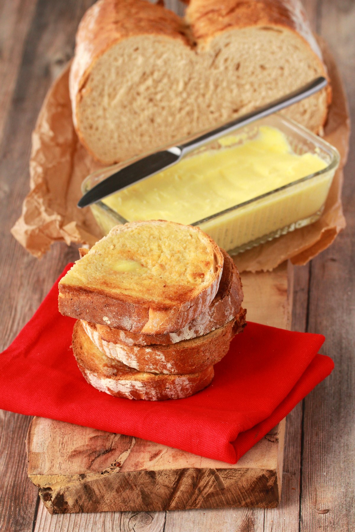 Slices of toast spread with vegan butter on top of a red napkin. 