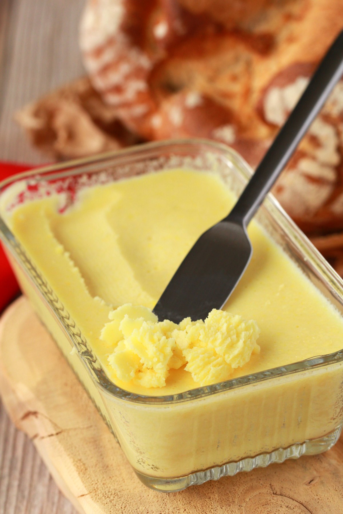 Vegan butter in a glass butter dish with a butter knife. 