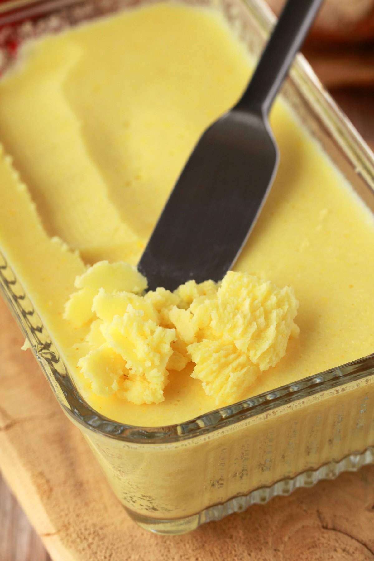 Homemade vegan butter in a glass butter dish with a butter knife.