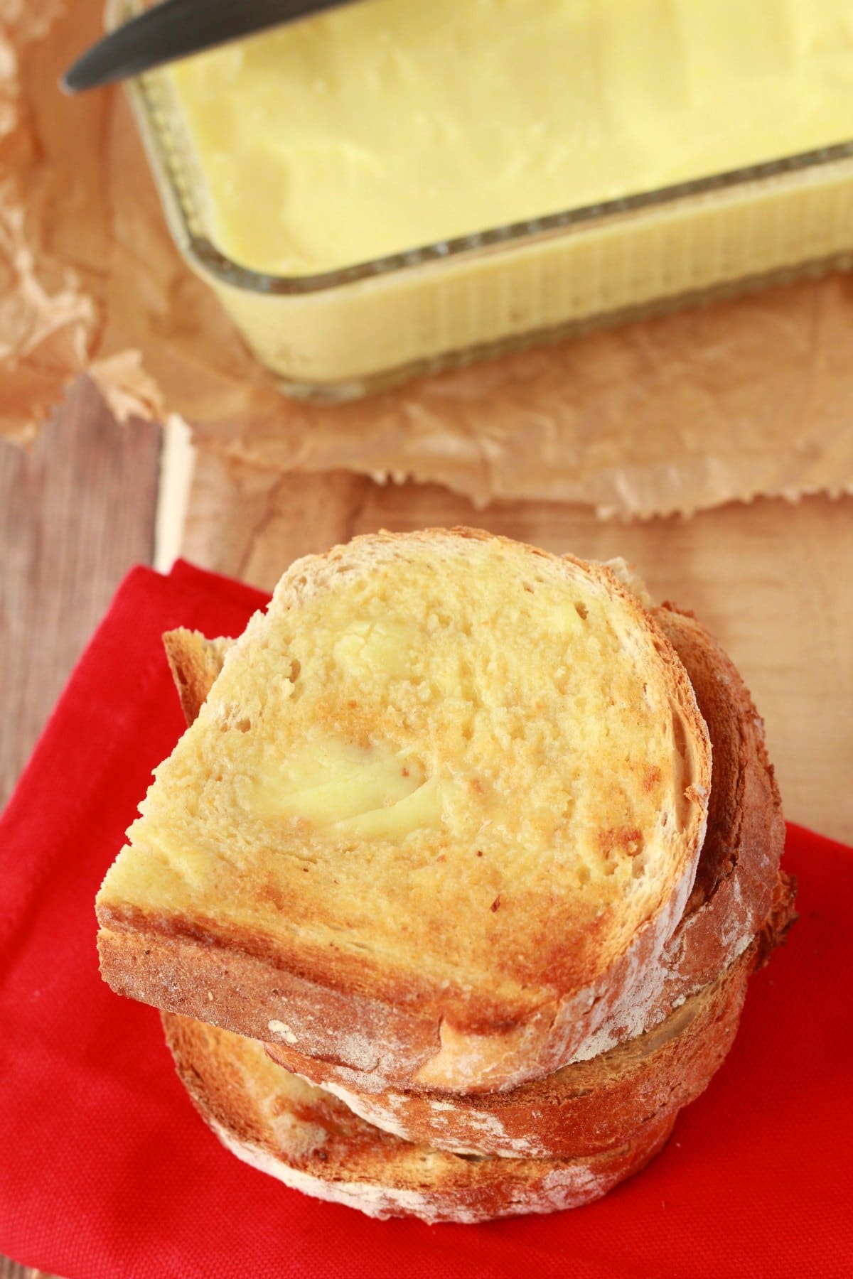 Slices of toast spread with vegan butter on top of a red napkin. 