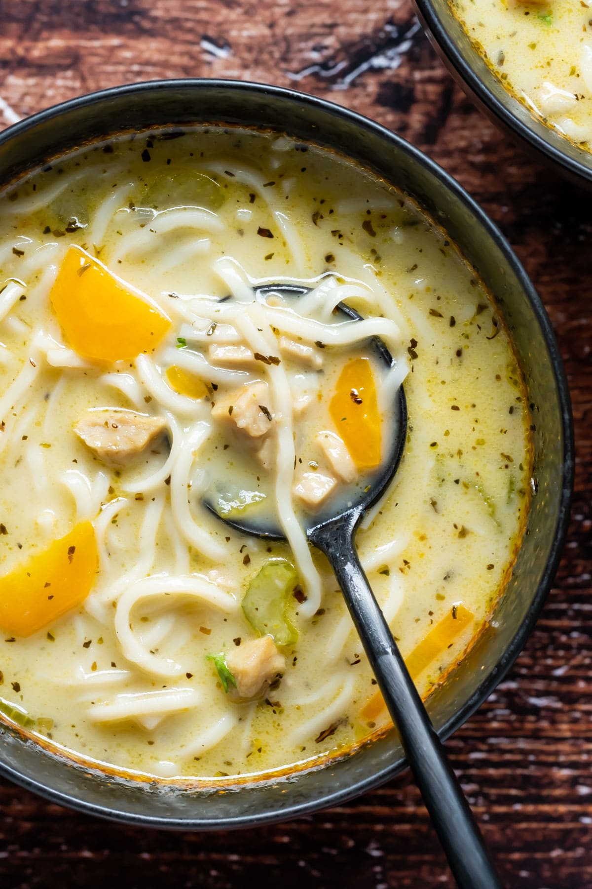 Vegan chicken noodle soup in a bowl with a spoon.