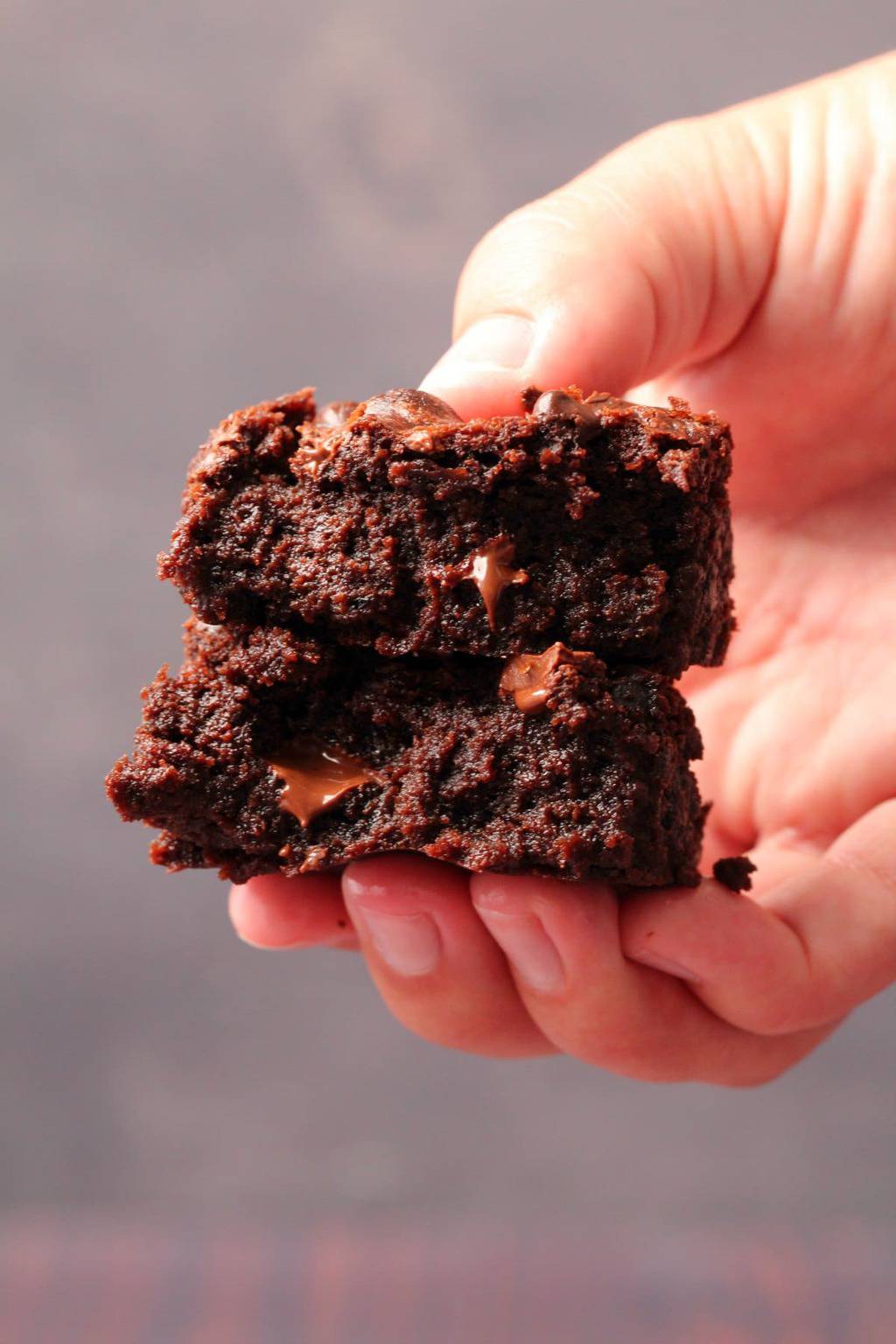 Vegan chocolate brownie broken in half to show the center. 