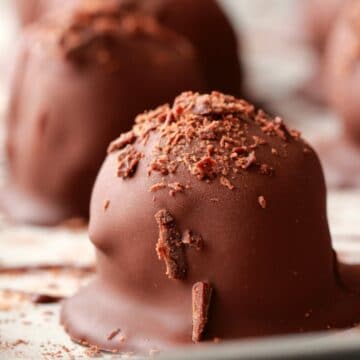 Vegan chocolate truffles on a parchment lined baking tray.