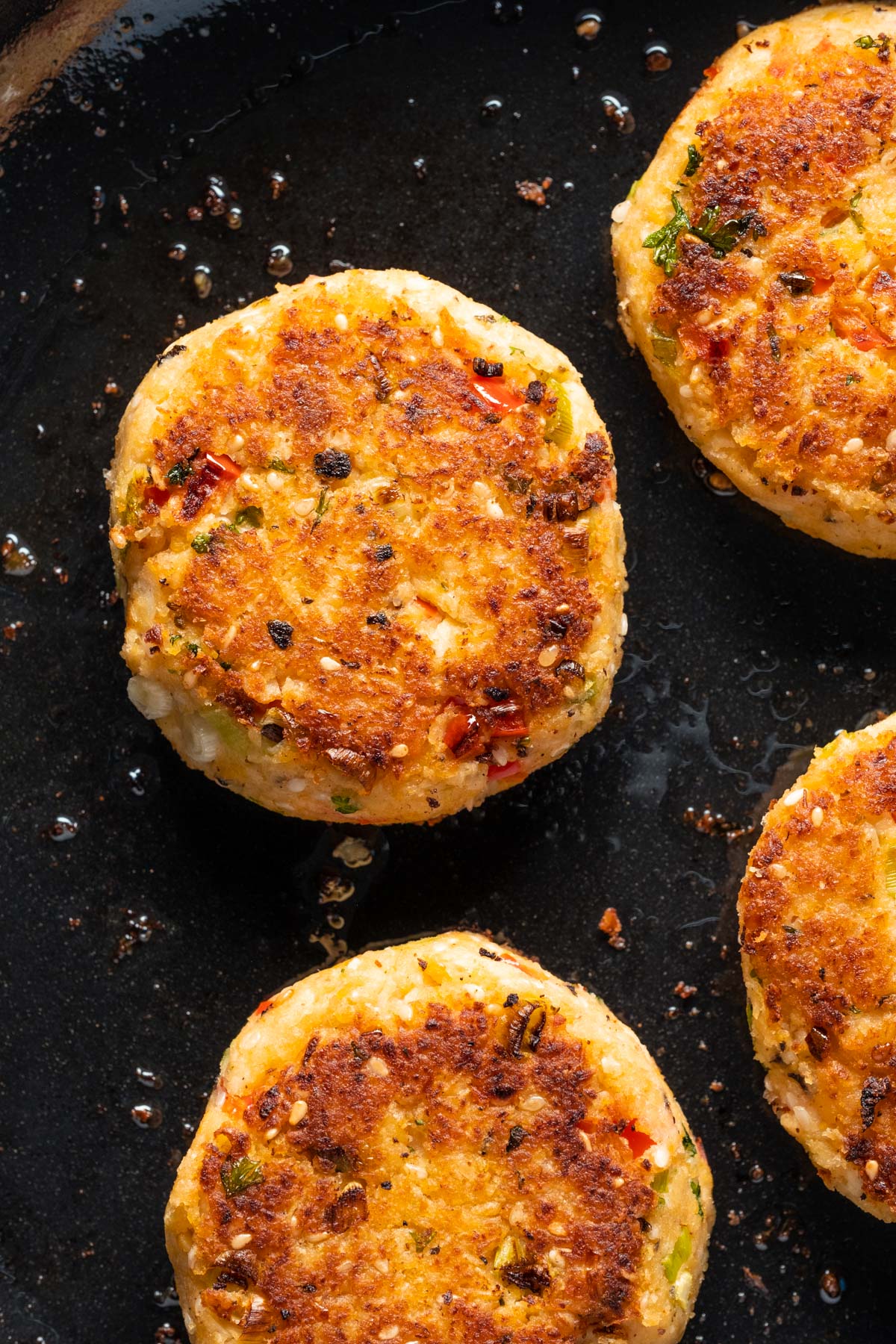 Vegan crab cakes in a frying pan.