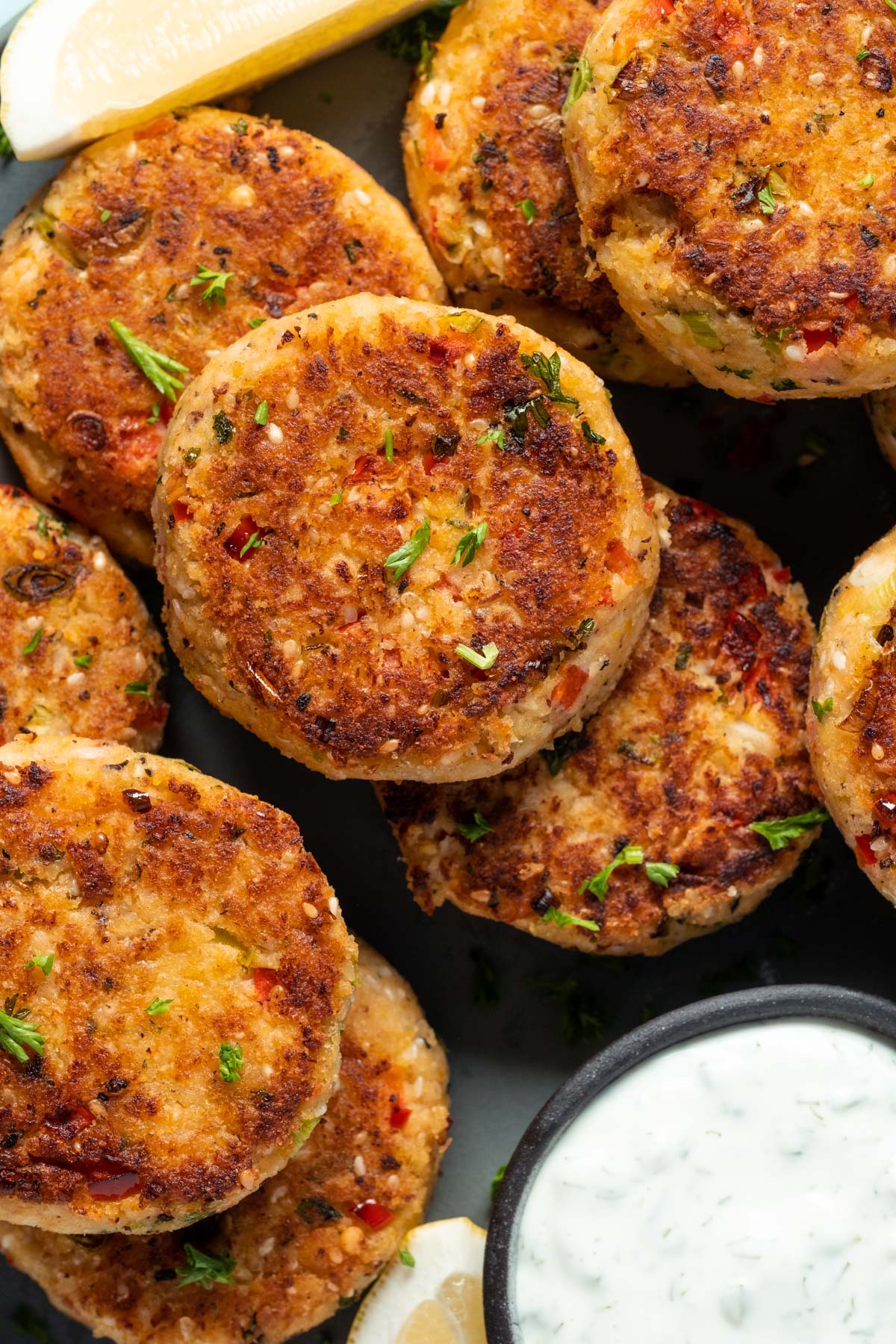 Vegan crab cakes on a plate with tartar sauce.