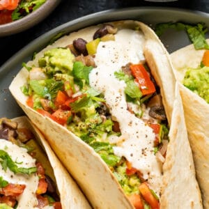 Fully loaded vegan fajitas on a gray plate.