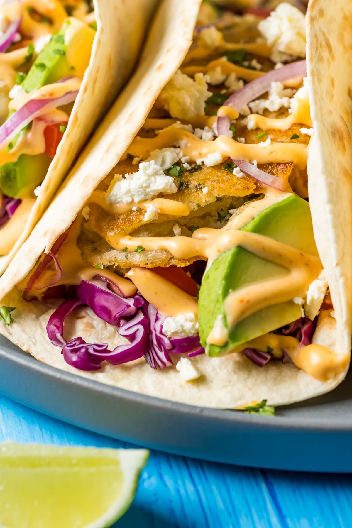 Vegan fish tacos on a gray plate. 