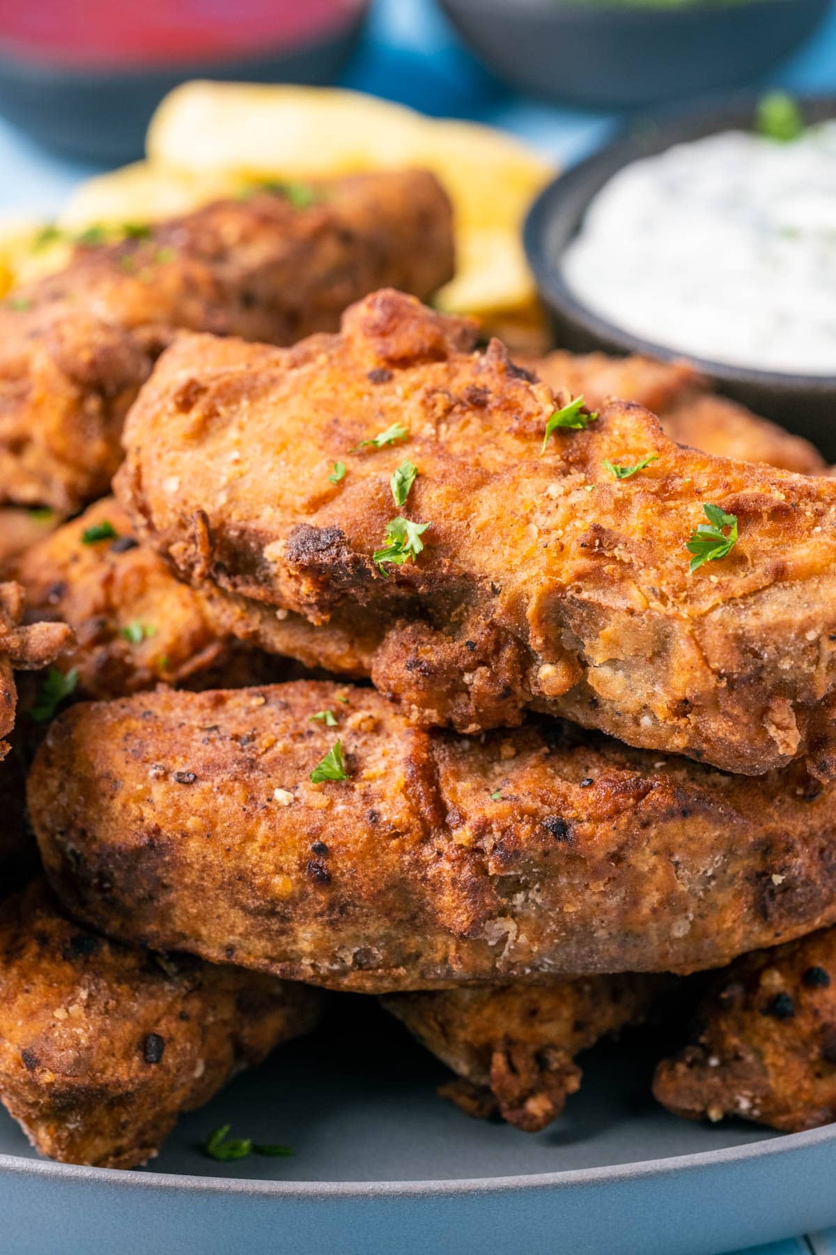 Vegan fried chicken pieces on a plate with vegan ranch dressing and chips.