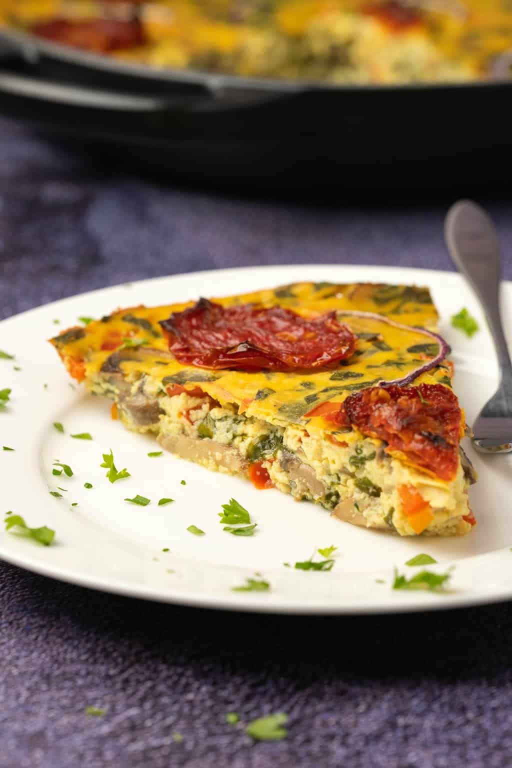 Slice of vegan frittata on a white plate. 