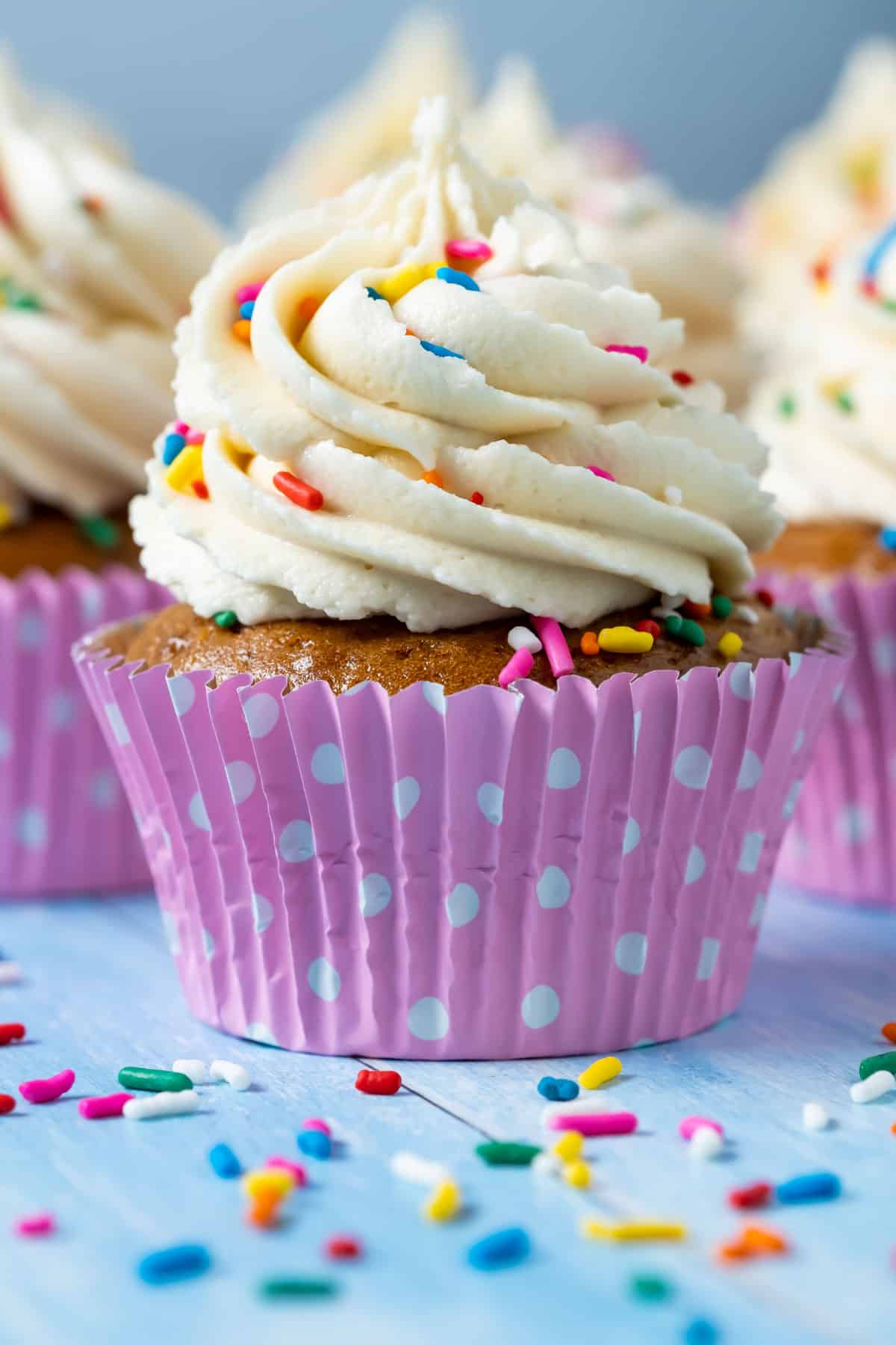 Vegan gluten free vanilla cupcakes topped with frosting and sprinkles.