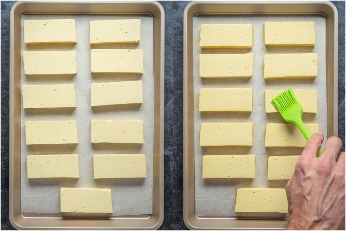 Slices of vegan halloumi on a parchment lined baking sheet and then brushed with olive oil.