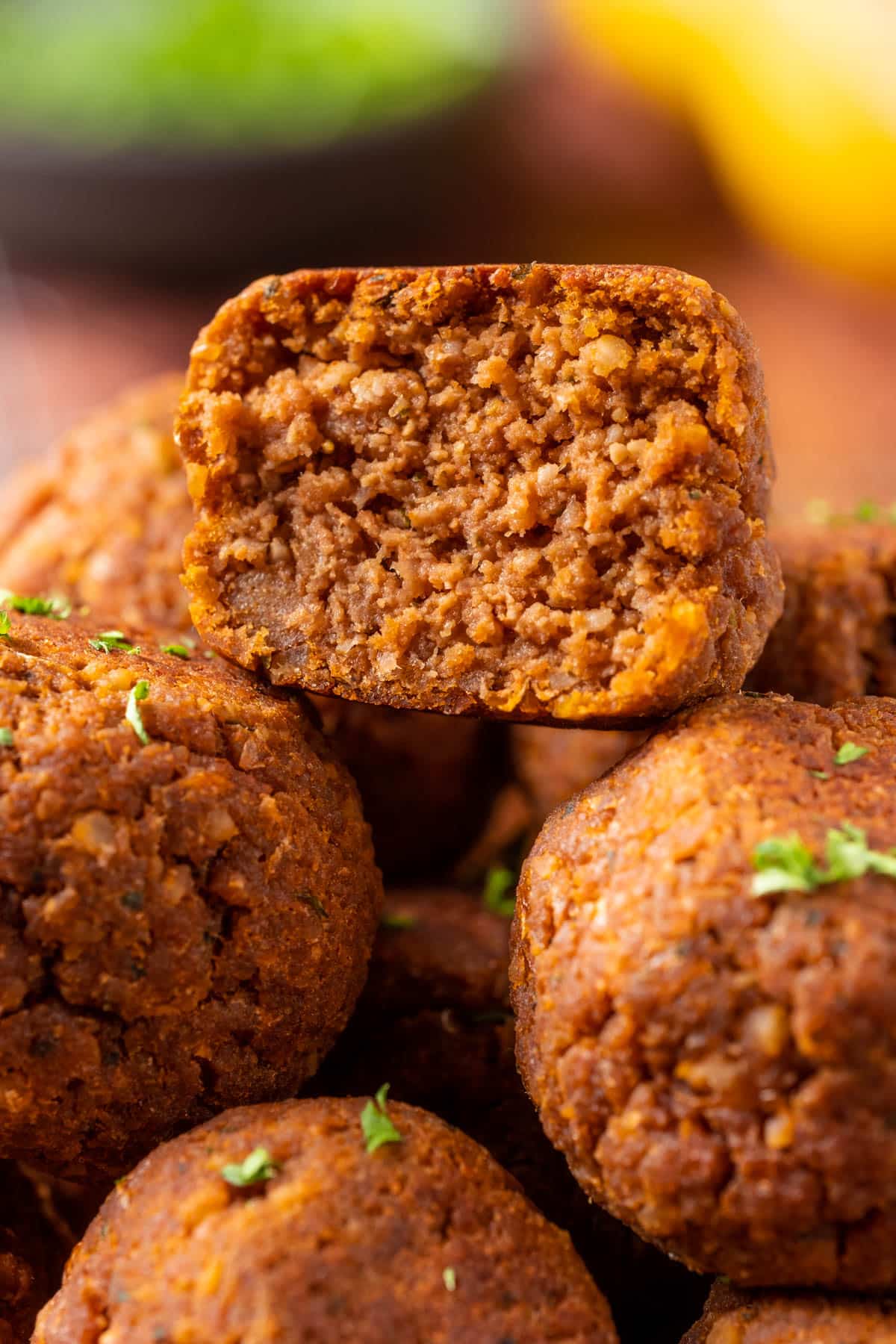 Stack of vegan meatballs with the top meatball cut in half.