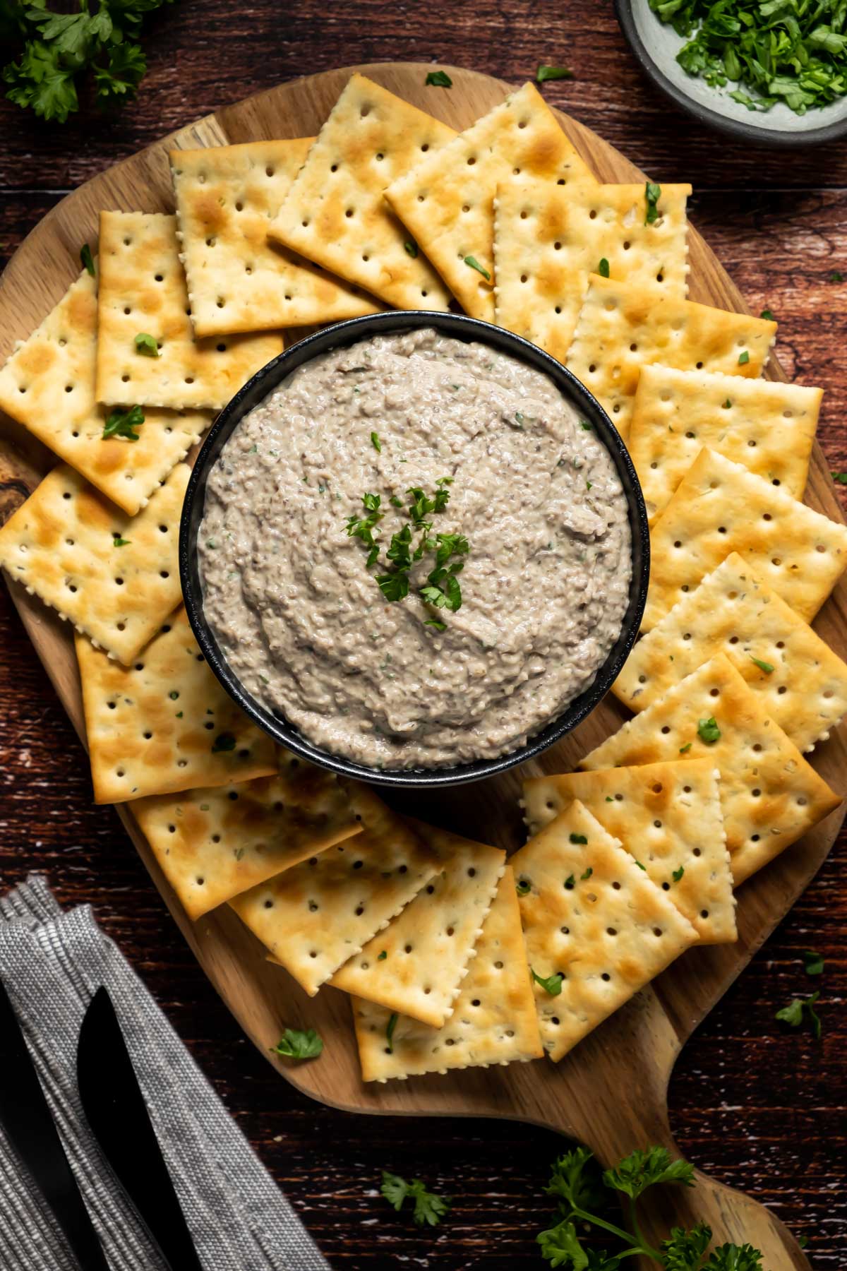 Vegan mushroom pâté in a black bowl with crackers. 