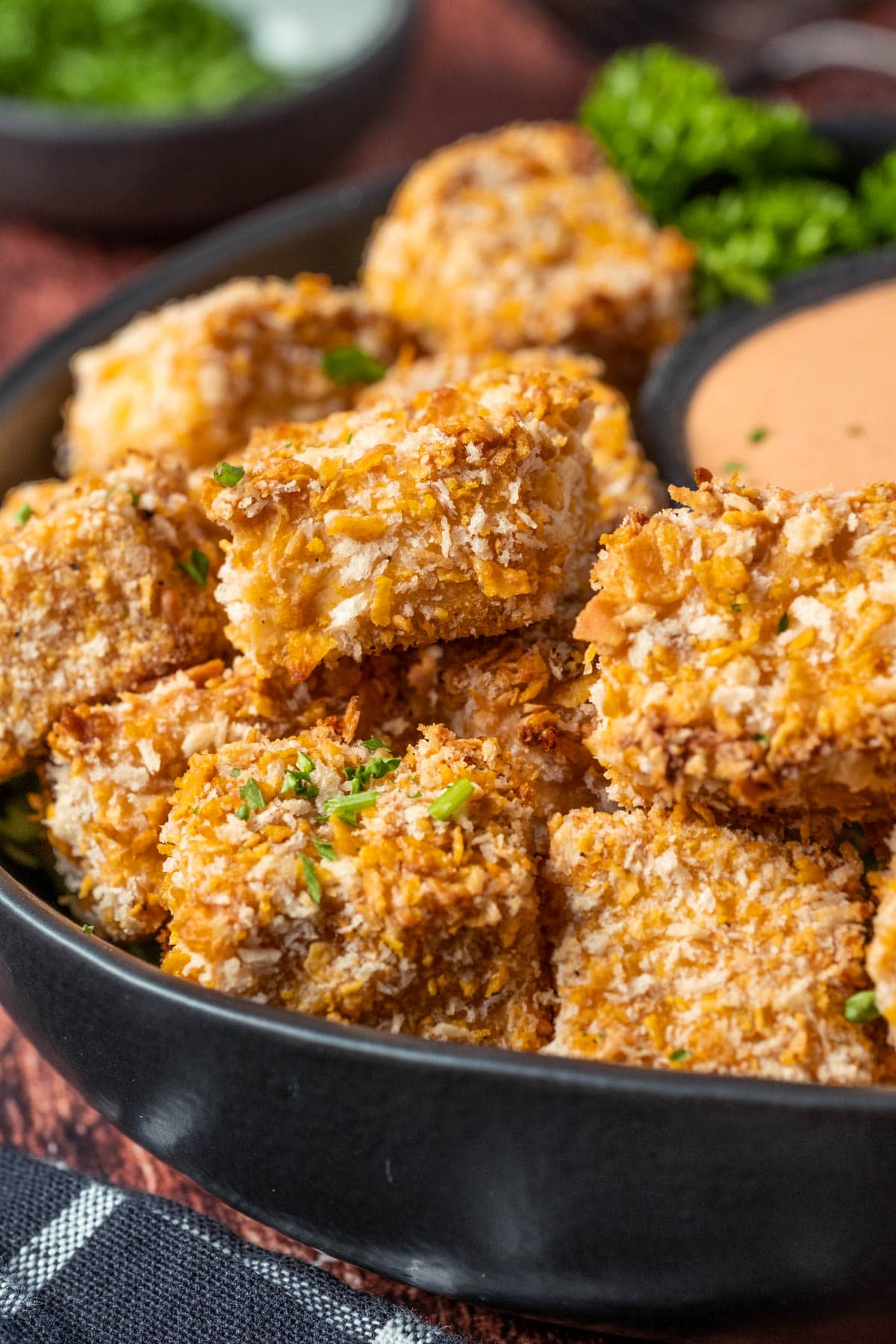 Vegan chicken nuggets stacked up on a plate.