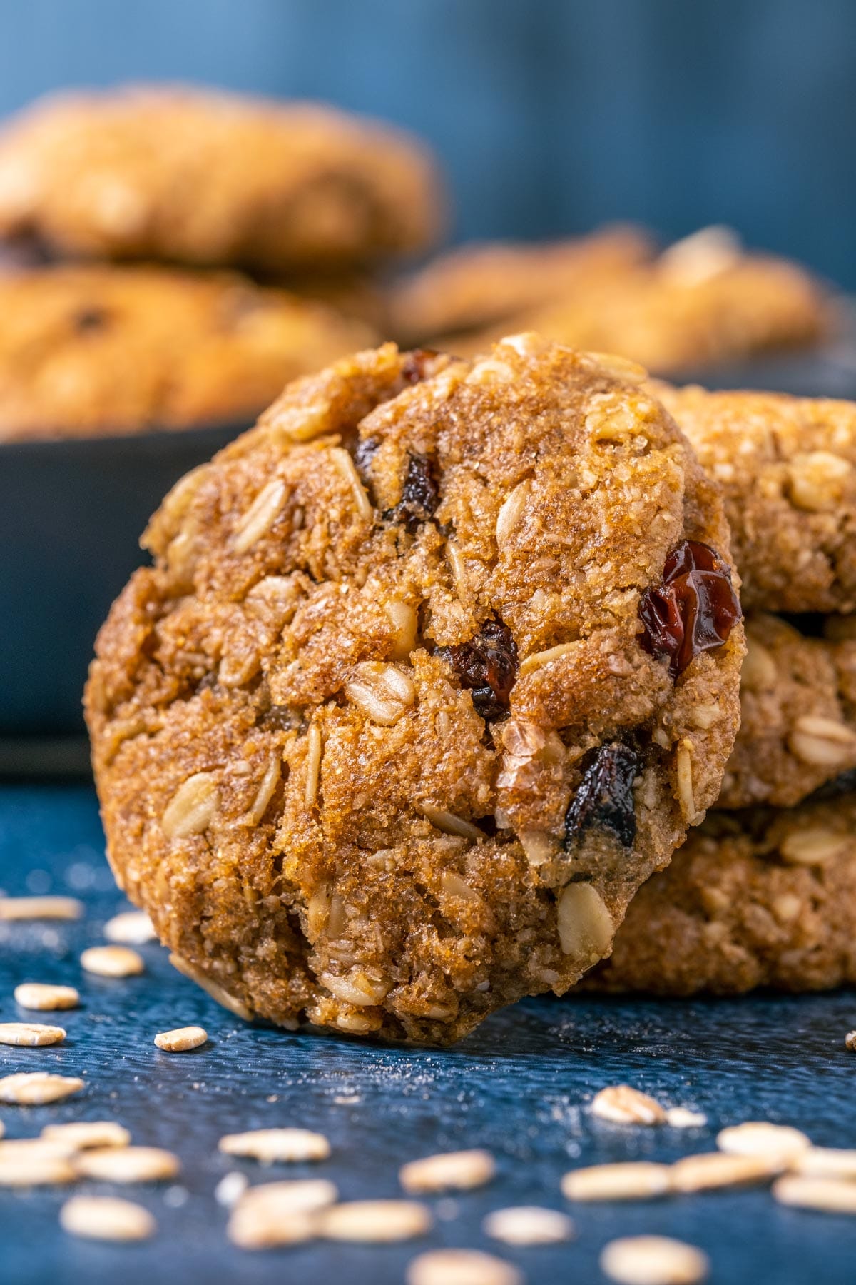 Vegan oatmeal raisin cookie leaning against a stack of cookies.