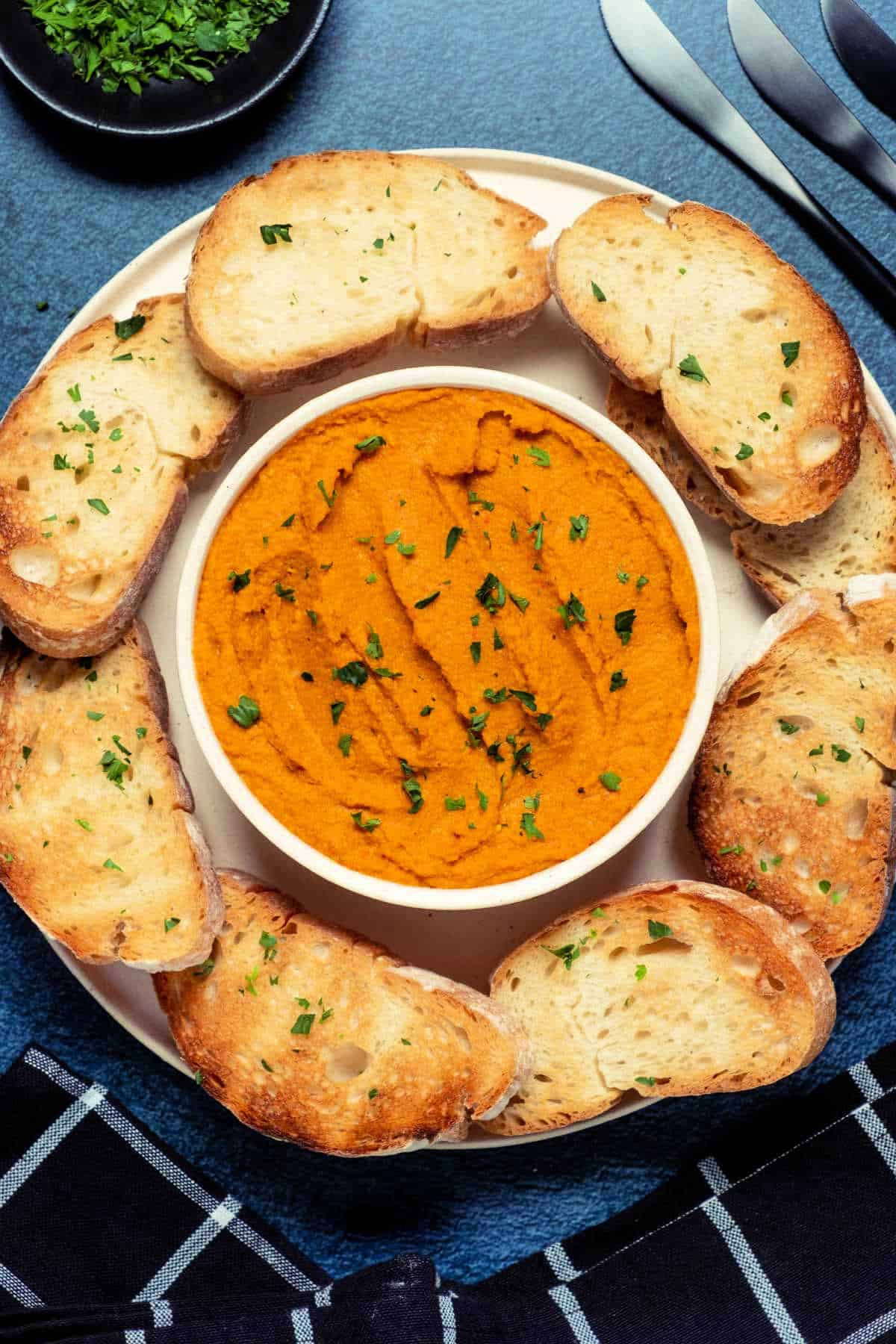 Vegan pâté in a white bowl topped with parsley. 