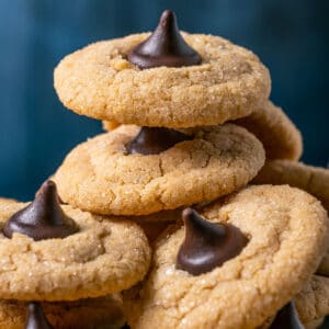 Vegan peanut butter blossoms stacked up on a plate.