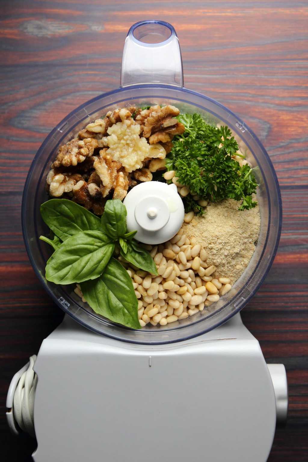 Ingredients for a vegan pesto in a food processor ready to process. 