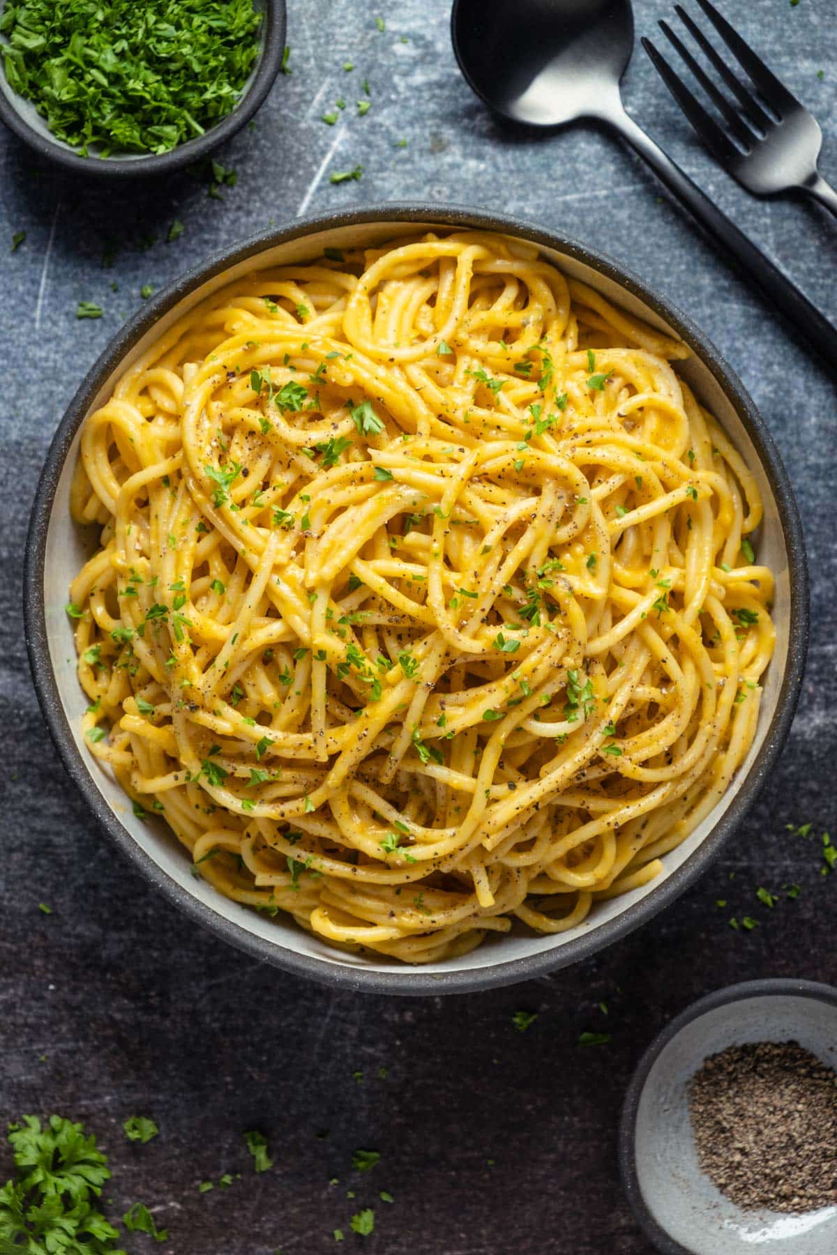 Pumpkin pasta topped with chopped parsley and ground black pepper. 