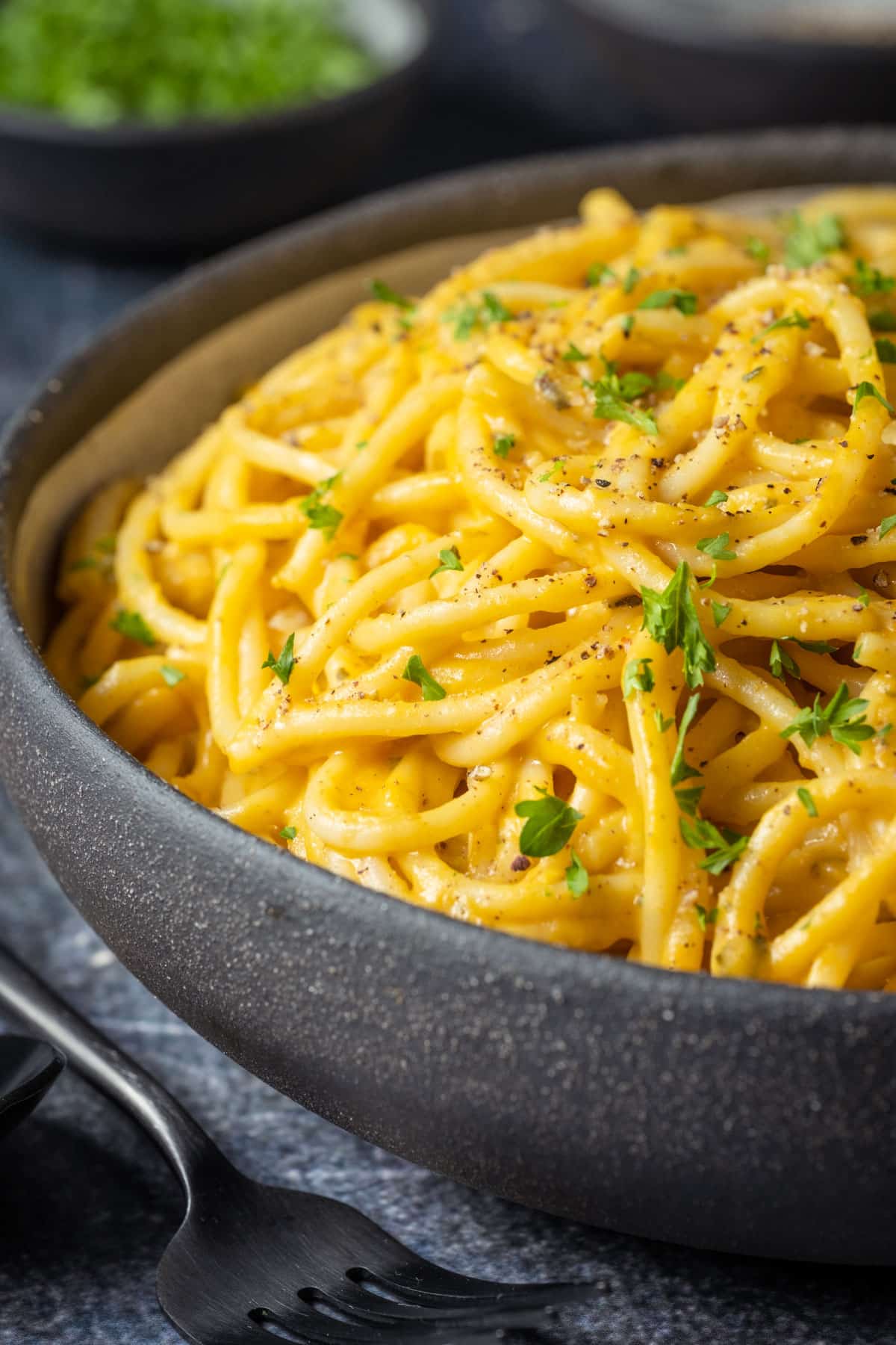 Pumpkin pasta topped with chopped parsley and ground black pepper.