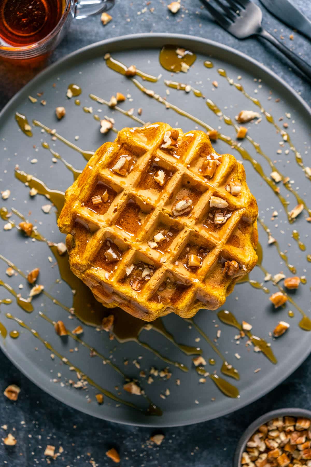 Overhead of pumpkin waffles on a gray plate.