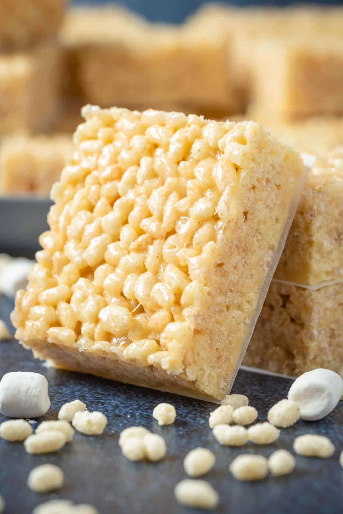 Vegan rice krispie treat leaning against a stack of rice krispie treats.