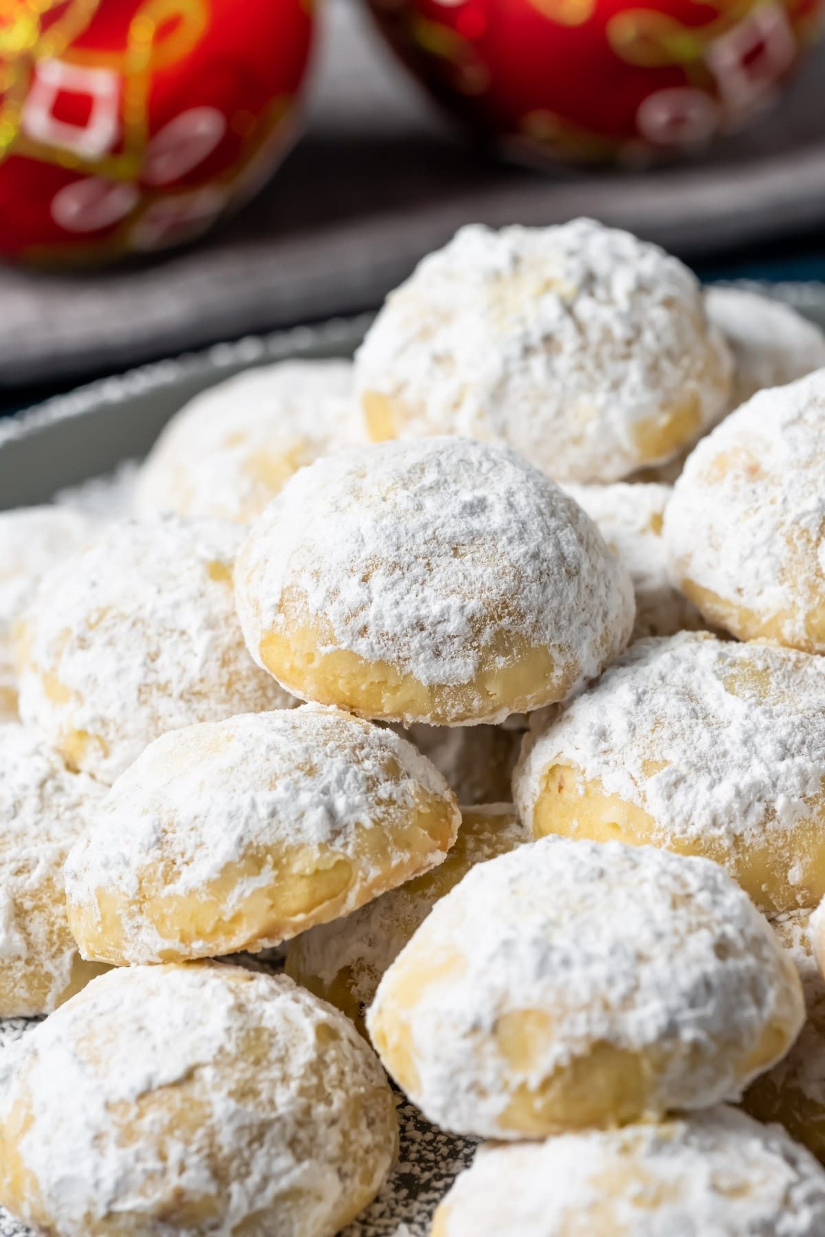 Snowball cookies stacked up on a plate.