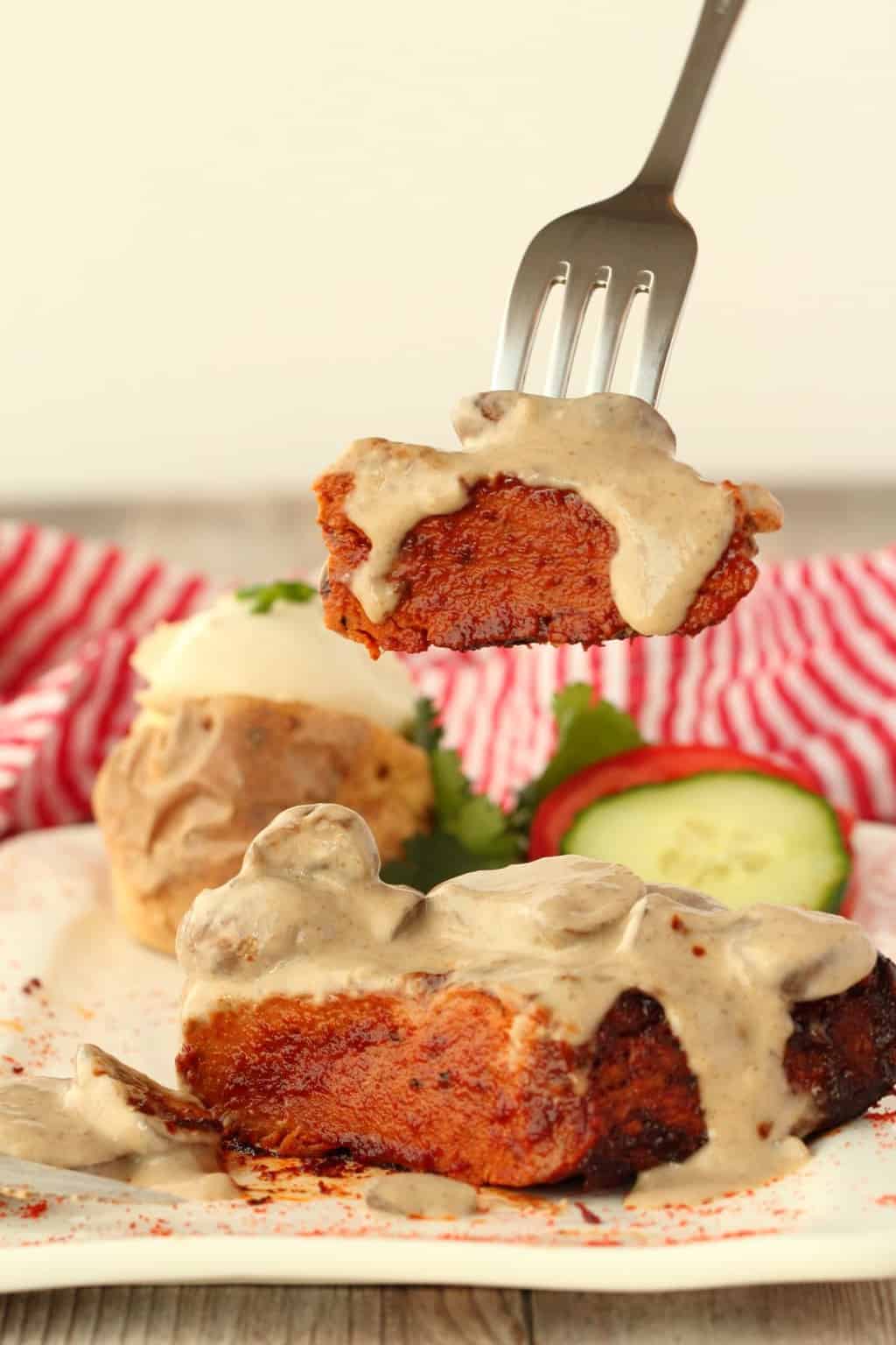 Vegan steak with mushroom sauce on a white plate. 